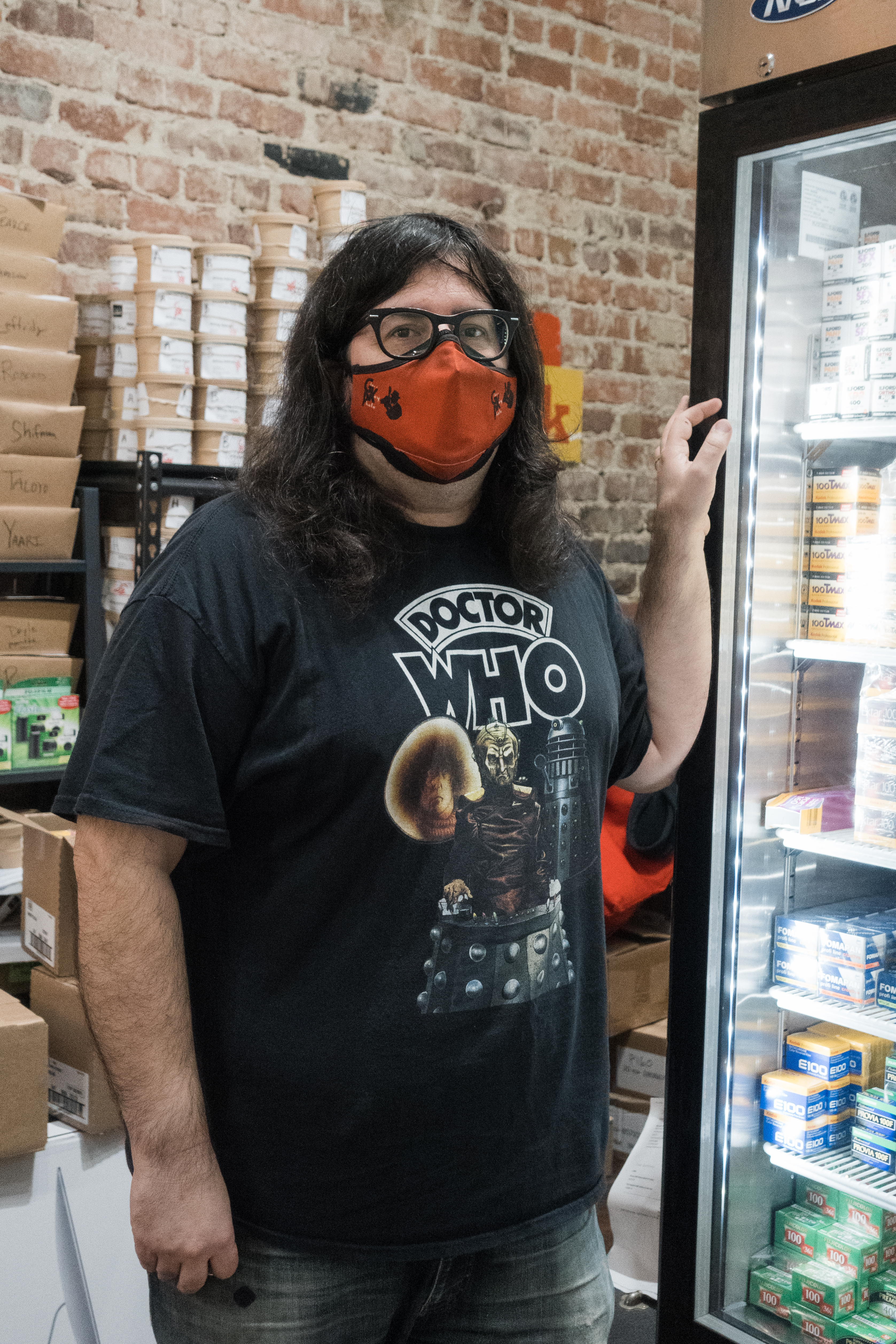 Matt poses next to the fridge in which he keeps the store's film.